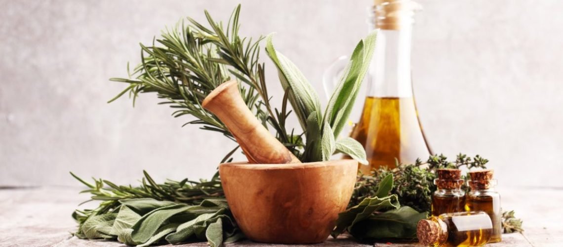 Fresh herbs from the garden and the different types of oils for massage and aromatherapy. Wellness concept